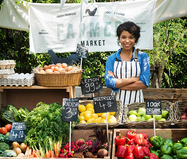 female vendor standing at a farmers market