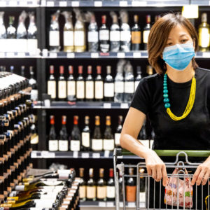 Woman with mask shopping in liquor store